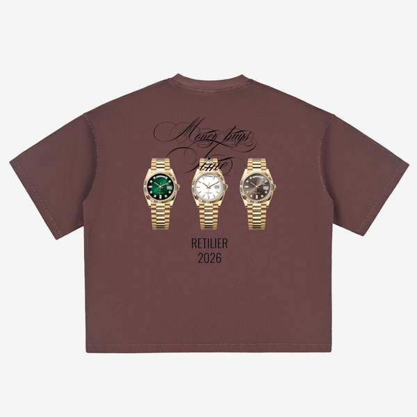 A brown short-sleeve t-shirt shown flat against a light gray background, featuring a graphic print of three gold-tone wristwatches with green, white, and black dials, accompanied by the text 'Many times Partie' and 'RETIPIER 2026'.