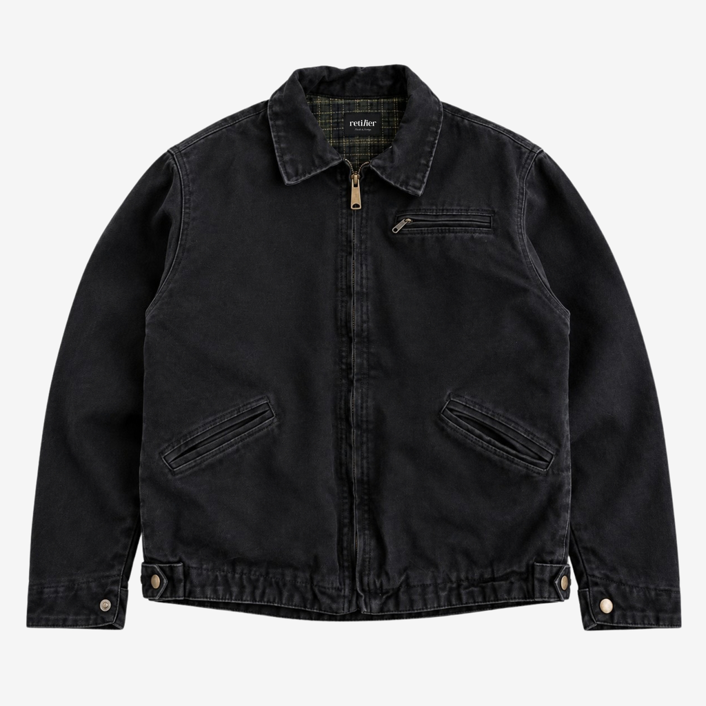 A black washed canvas utility jacket with a zippered front, collar, and flap pockets, shown flat on a light gray background.